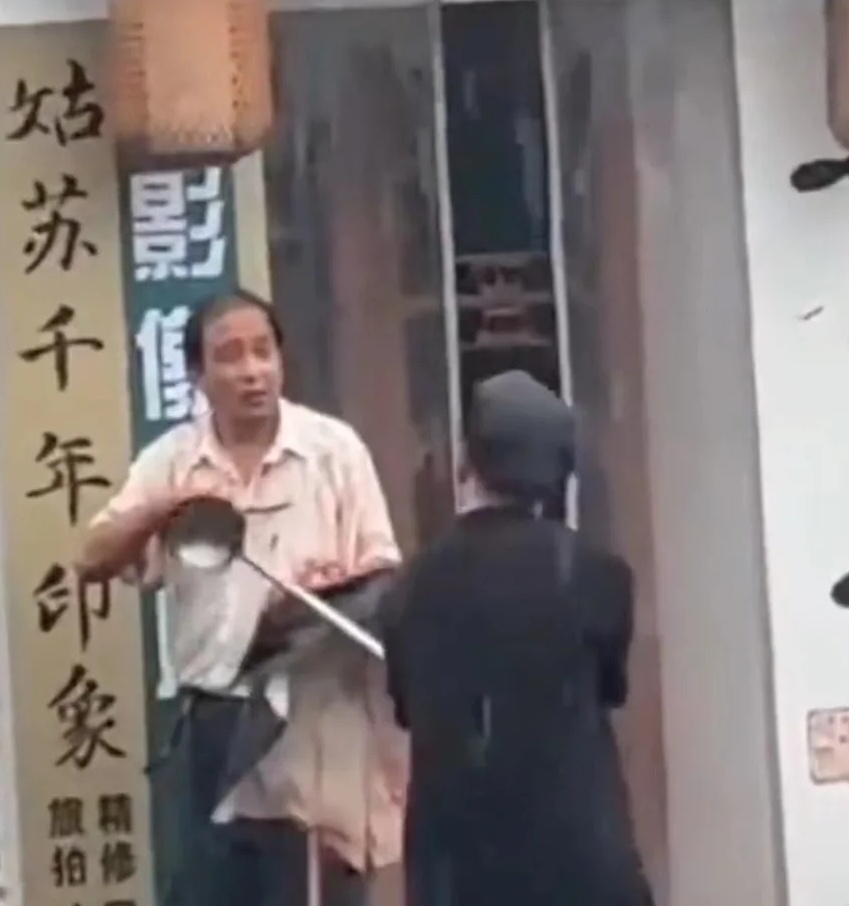 男子街头持刀伤人，卤味店店主持长勺与其对抗救下受害者(图1)